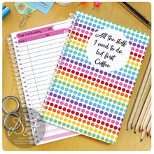 Load image into Gallery viewer, A colorful dot-patterned planner with the text 'All the stuff I need to do but first Coffee' on the cover, lying next to pencils and a pair of scissors.